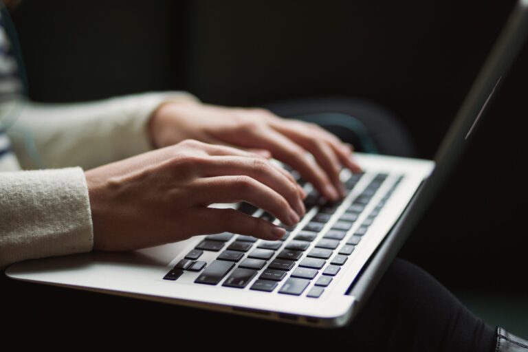 A imaxe amosa as mans dunha rapaza traballando sobre o teclado dun ordenador portátil, en alusión a un dos obradoiros da Normal, que está adicado á creación e coidado dun blog