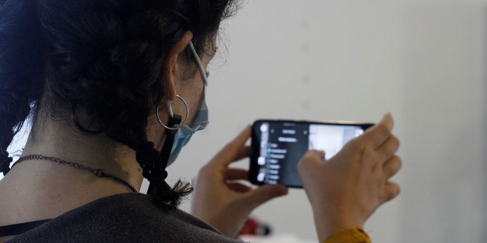 Unha participante no obradoiro de creación audiovisual practica técnicas de gravación co seu teléfono móbil. O obxectivo é a elaboración de diversos contidos dixitais